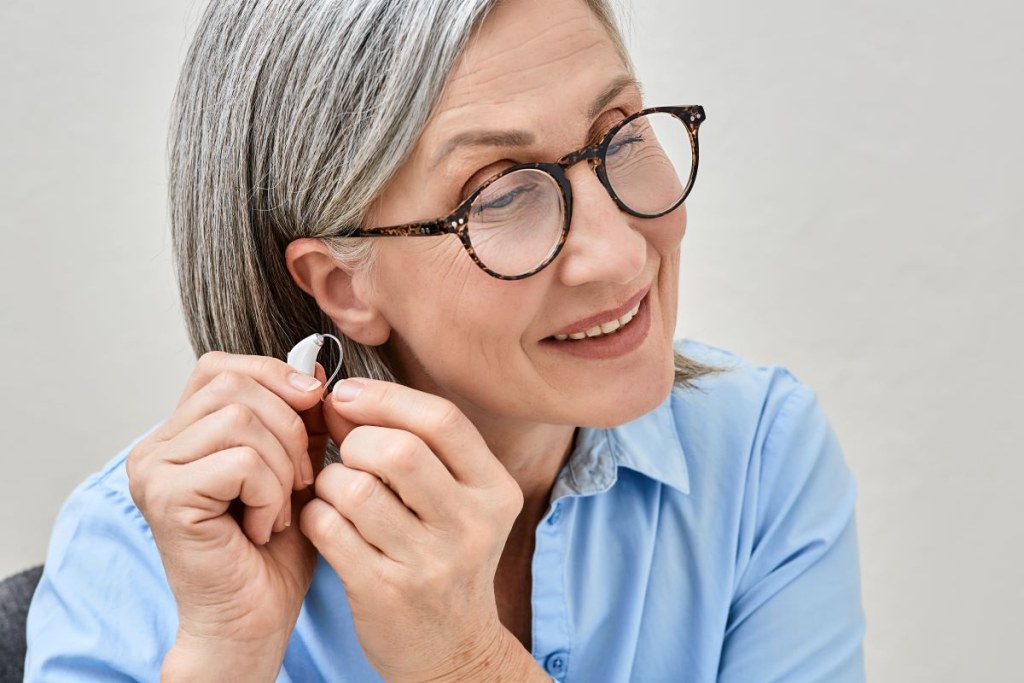 A woman inserts a hearing aid