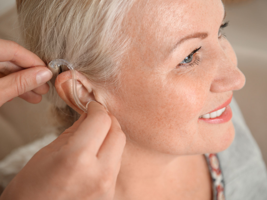 lady putting on hearing aid
