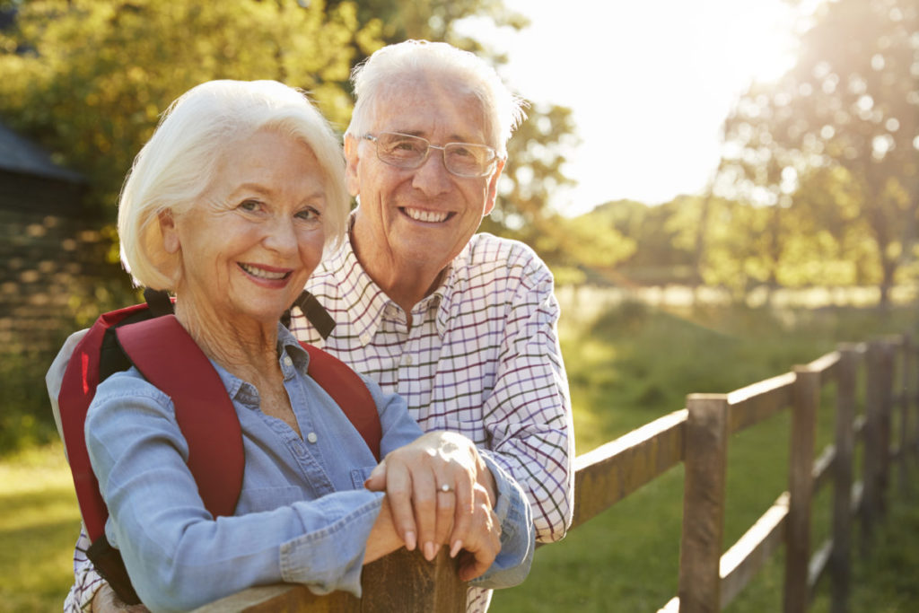 Portrait Of Senior Couple Hiking In Countryside Together