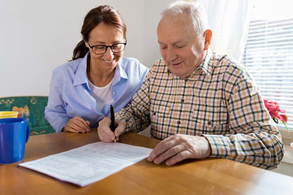 Elderly man filing paperwork with woman