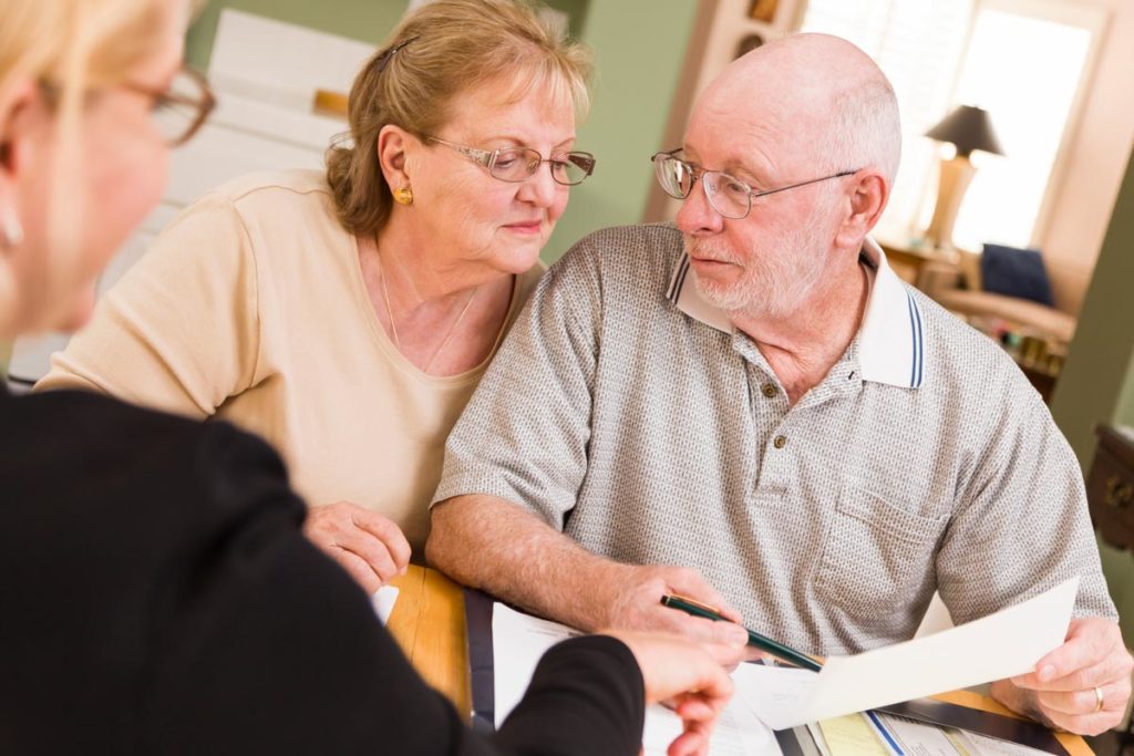 Senior couple discussing health insurance with provider