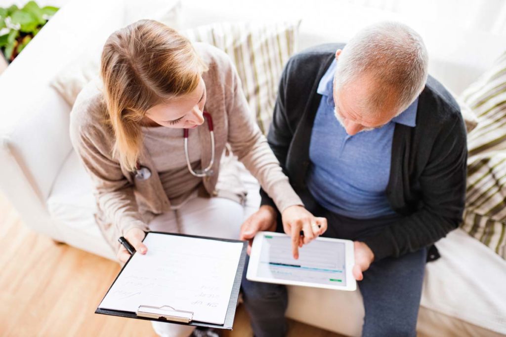 Patient talking with doctor holding tablet