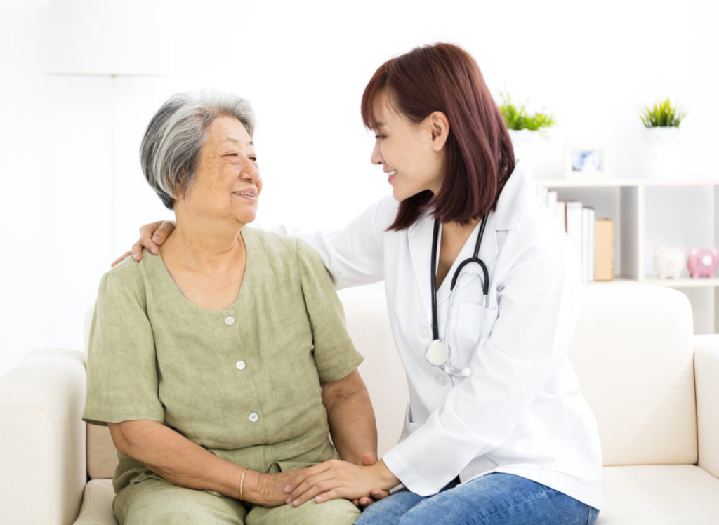 young smiling home caregiver with senior woman