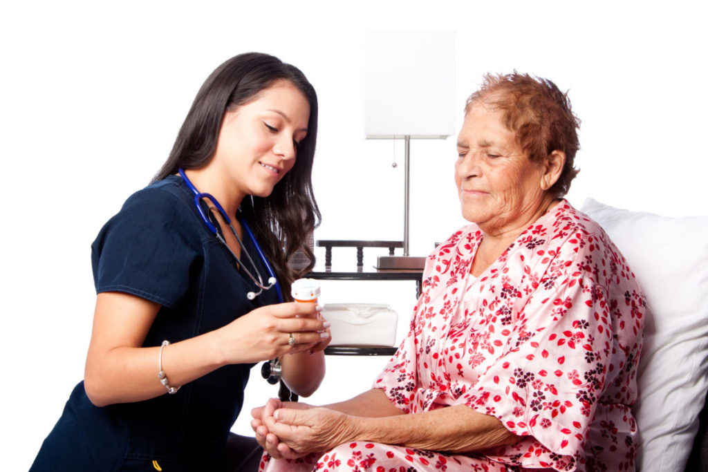 Female Hispanic Nurse taking care of female Hispanic patient