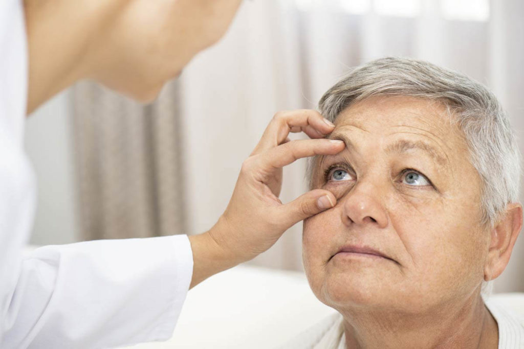 doctor checking seniors eyes
