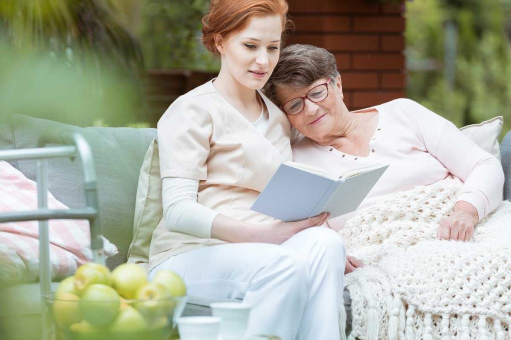 hospice nurse reading to older women