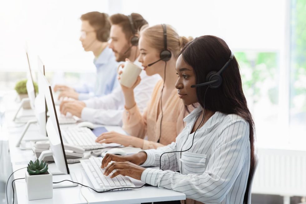 line-of  call centre employees with headphones work