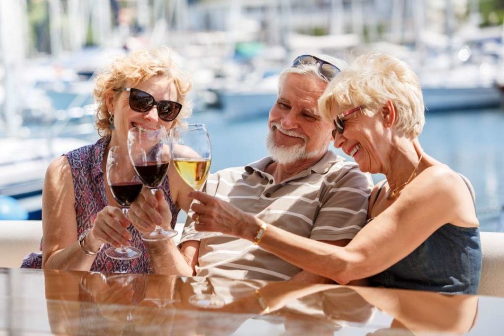 Elderly friends drinking wine on boat
