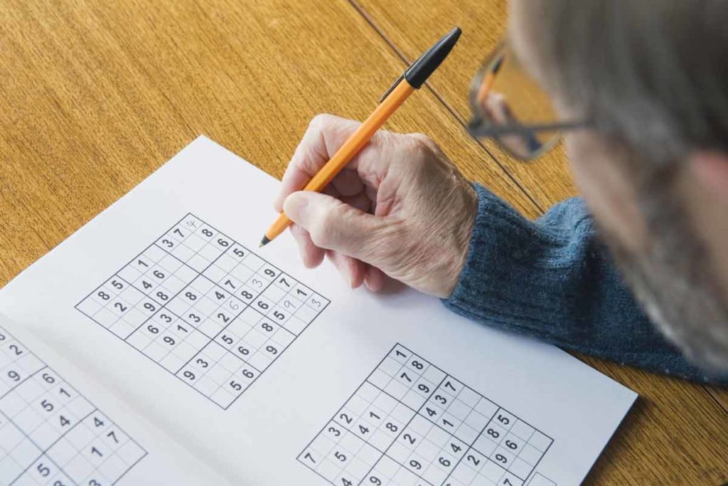 man doing sudoku puzzle