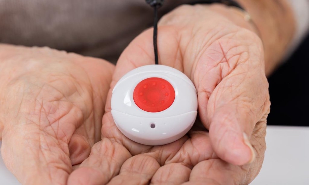 Close-up Of Senior Woman Holding Alarm Button For Emergency