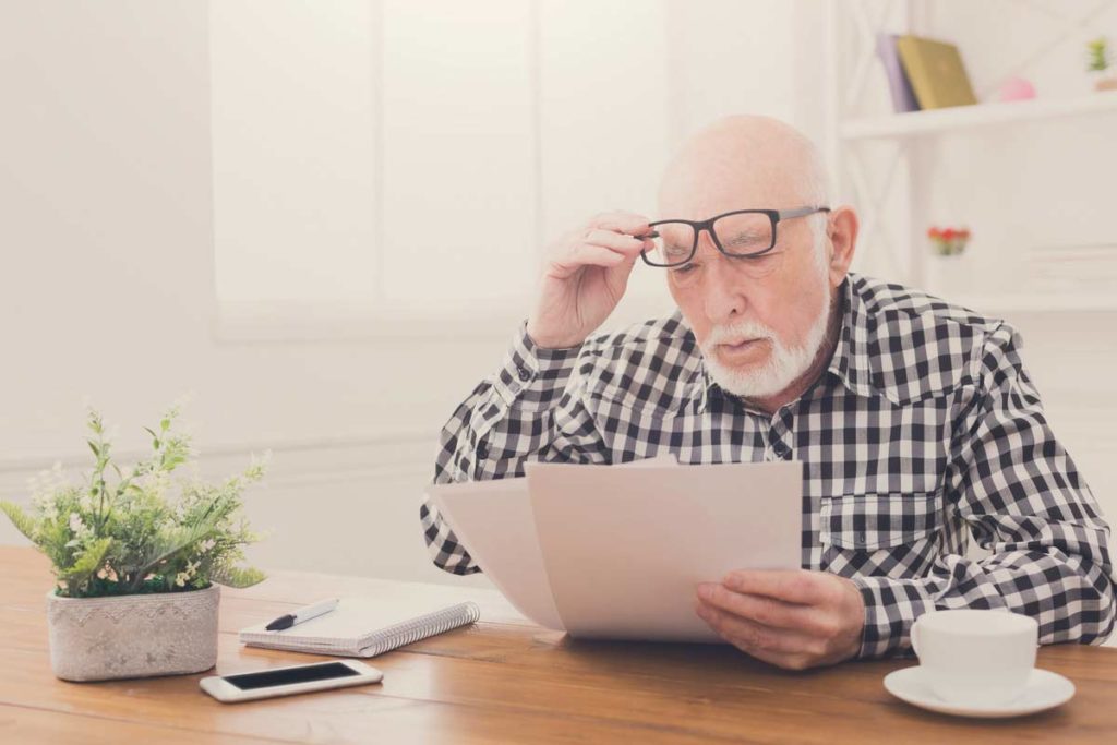 old man looking at home improvement bills