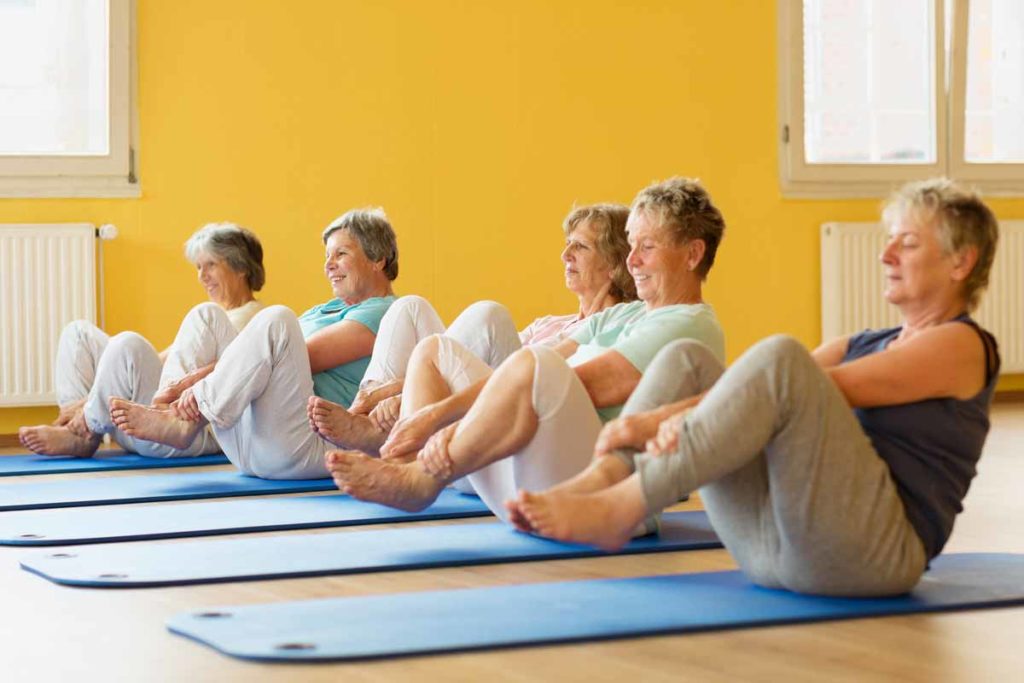 older women doing yoga