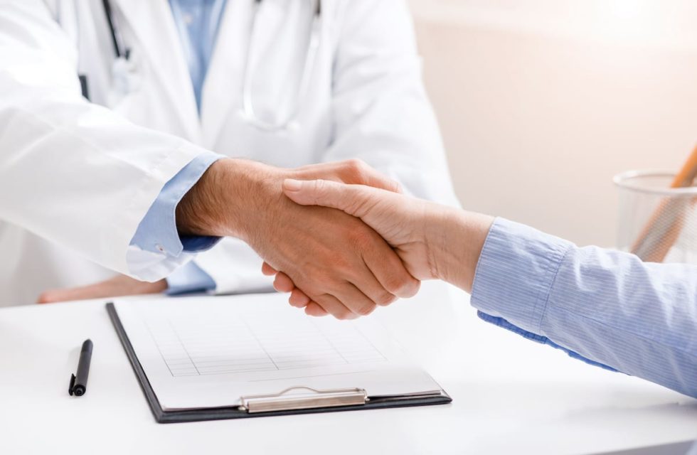 senior female patient shaking hands with doctor