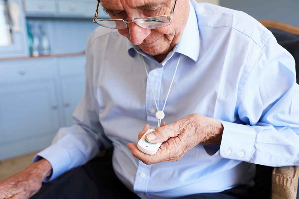 Senior man in a blue shirt using a medical alert necklace