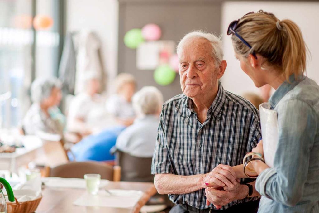 young woman talking to older man with dementia